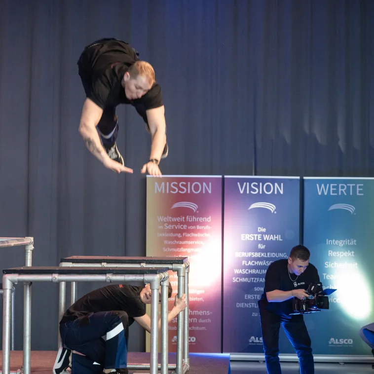 Mann springt &uuml;ber Tisch